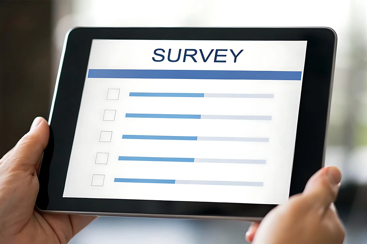 Our Services 3 Hands holding a tablet with a digital survey form on the screen.