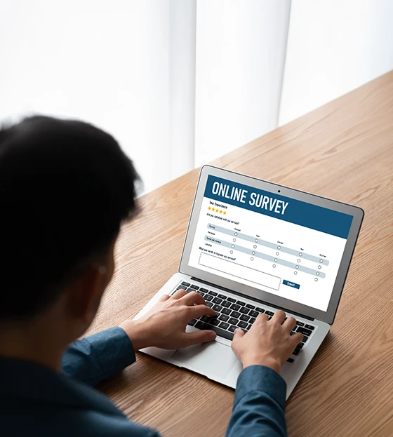 Person completing Online Surveys on a laptop for digital market research feedback.